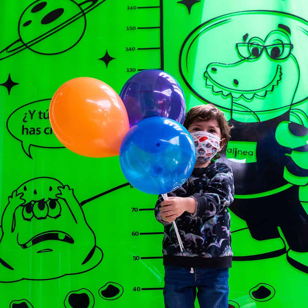Paciente niño feliz con unos globos despues de consulta en Alinea Vision y Dental
